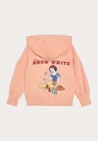 Hoodie couleur pêche avec un capuchon à cordon de serrage. Présente un graphique de Blanche-Neige entourée d'animaux au dos. Matière douce en coton.
