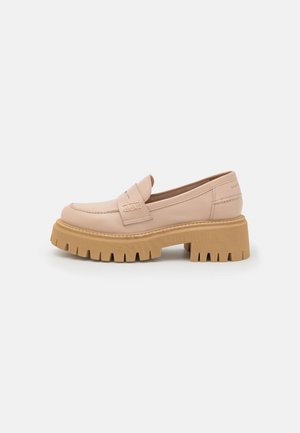 Beige læderloafer med kraftig sål med riller og en synet remdetalje henover overdelen.
