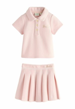 Hellrosa kurzärmeliges Poloshirt mit goldenen Knöpfen und passendem plissiertem Rock, beide mit "Baker"-Schriftzug in Gold.