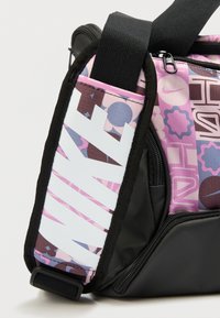 Sac en tissu noir avec des motifs graphiques roses et violets. Doté d'une sangle blanche contrastante à rayures diagonales et d'une poche zippée.