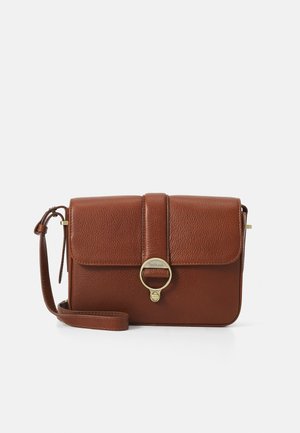 Brown leather crossbody bag with a textured finish, gold hardware, a flap closure, and a circular accent feature. Adjustable strap included.