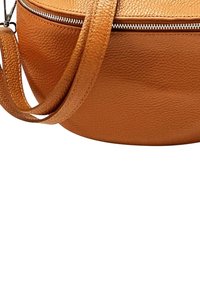Ronde, gestructureerde bruine leren schoudertas met een ritssluiting en een verstelbare schouderband, met een gladde afwerking en een strakke vormgeving.
