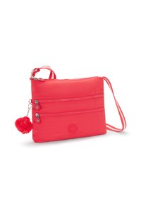 Rød nylon crossbody taske med tre lynlåslommer, et cirkulært logo og en fluffy abe charme hængende ved lynlåsen.