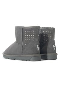 Botas de tobillo de ante gris con una textura suave, presentan acentos de tachuelas plateadas a los lados y una suela de goma plana con un logotipo.