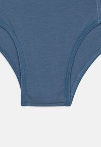 Slip in cotone blu con una texture liscia, caratterizzato da cuciture piatte e una vita elastica per il comfort. Il design è semplice e funzionale.