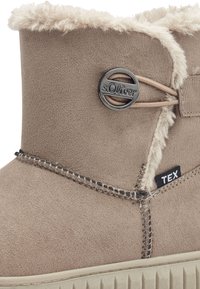 Brune ruskinds ankelstøvle med faux fur-for, dekorativ metalknap og stikninger. Har et sort "TEX" mærke på siden.