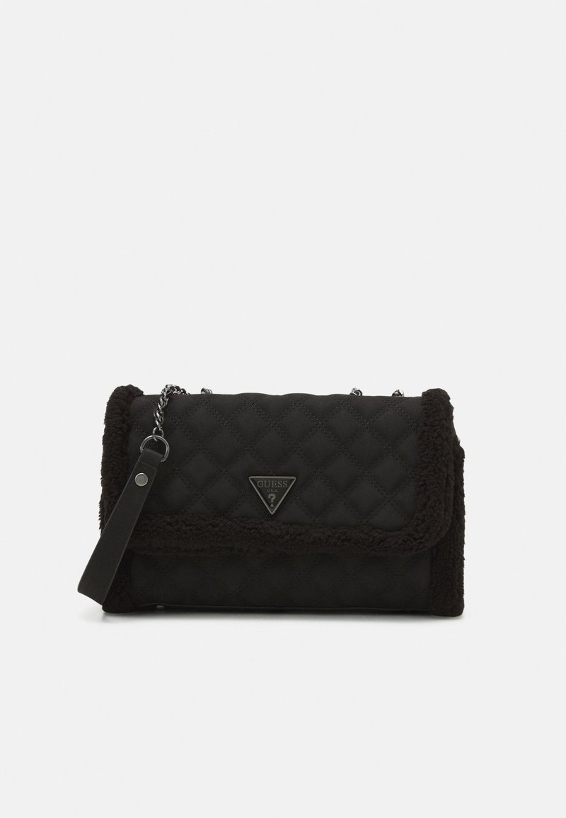 Sac à épaule matelassé noir avec bandoulière chaîne, bordure en fausse peau de mouton et logo triangulaire Guess sur le rabat avant.