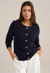 Navy knitted cardigan with ribbed texture, round neckline, and front pockets. Features gold-tone buttons along the center.