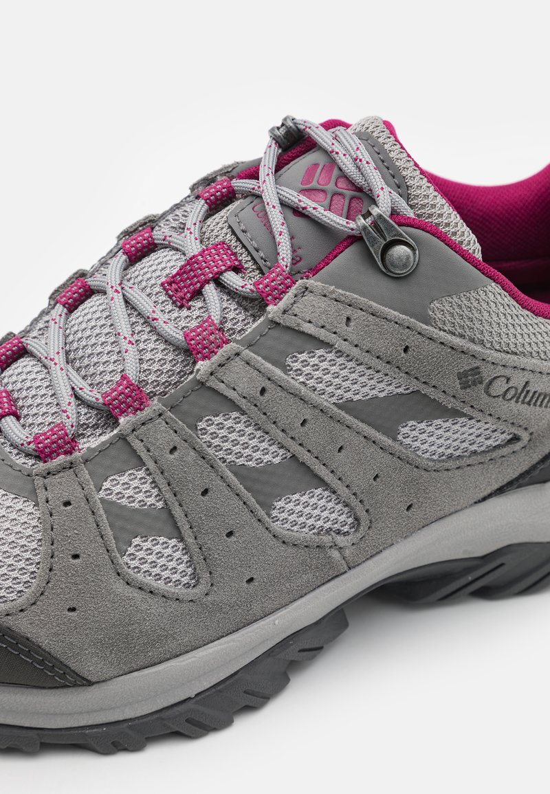 Chaussure de randonnée grise avec des matériaux en mesh et en daim, arborant une combinaison de couleurs grise et violette, des lacets sécurisés et une semelle en caoutchouc texturée.