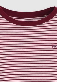 Raudono vyno ir šviesiai rožinės spalvos dryžuota trumpomis rankovėmis marškinėliai, su apvaliu kaklu ir maža Levi's logotipo etiketė kairėje pusėje.