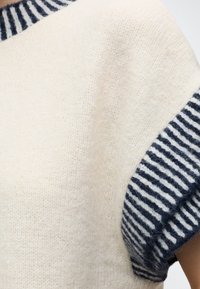 Pull en maille crème avec manches courtes côtelées rayées bleu marine et blanc et bord de col.