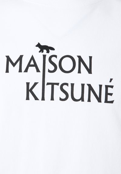 Bílý bavlněný tričko s černým textem "MAISON KITSUNÉ" a malou černou siluetou lišky nad písmenem "I". Hladká textura, kulatý výstřih.