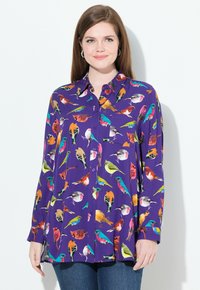 Camicia viola con bottoni caratterizzata da una stampa di uccelli colorati, con maniche lunghe e una vestibilità comoda. Il tessuto appare liscio con una texture leggera.