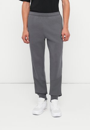 Grijze sweatpants met een taps toelopende pasvorm, voorzien van een gestructureerd onderpaneel, een elastische tailleband en aansluitende enkels. Logo-accent op de dij.