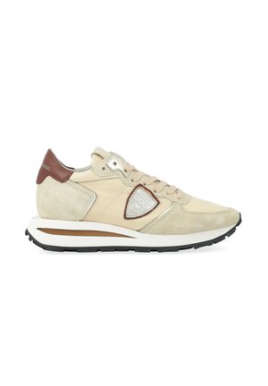 Sneaker bassa beige e marrone con pannelli in suede e tessuto, lacci e suola bianca imbottita con battistrada nera.