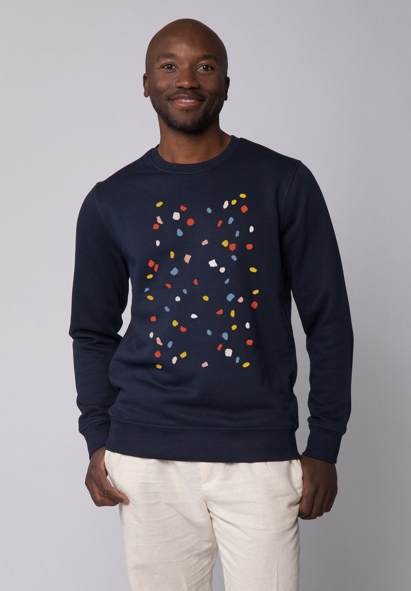 Marineblauwe sweatshirt met ronde hals, voorzien van een meerkleurig gespoten patroon van rood, geel, lichtblauw en wit aan de voorkant.