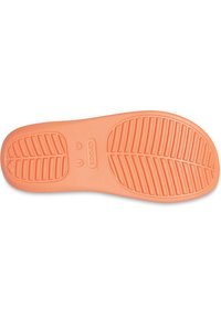 Suela de zapato de goma naranja con patrones de agarre texturizados, marcada con "crocs" y tamaño "W 7." Acabado suave con bordes redondeados.