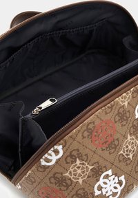 Brązowa torebka w wzory z zamknięciem na zamek, z materiałową wyściółką i logo w białym i czerwonym kolorze. Zawiera kieszeń na zamek.