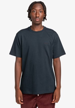 T-shirt in cotone navy scuro con vestibilità classica, scollatura rotonda e maniche corte. Presenta un logo tono su tono sul lato sinistro del petto.