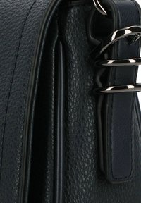 Marineblaues strukturiertes Lederhandtasche mit eleganten schwarzen Hardware-Akzenten und einem glatten Riemen, versehen mit sichtbaren Nähten und einer strukturierten Form.