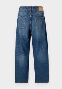 Jeans de denim azul oscuro, de corte relajado, con un acabado desgastado. Cuenta con dos bolsillos traseros y una etiqueta de cuero marrón en la cinturilla.