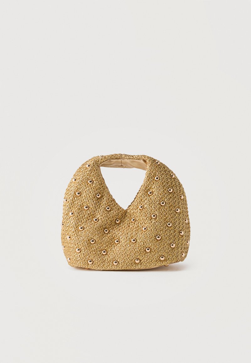 Μικρή πλεκτή μπεζ τσάντα χειρός με στρογγυλεμένο σχήμα και χρυσούς στρογγυλούς τρούκ καλύπτοντας ομοιόμορφα την επιφάνειά της, με κομμένη λαβή.
