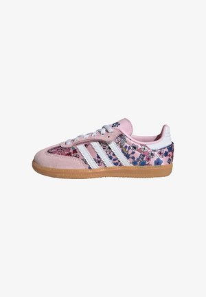 Rosa mocka- och tygsneaker med blommönster, vit design med tre ränder och sula av gummigummi. Har snörning.
