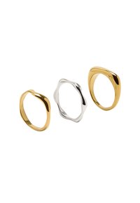 Trzy pierścionki wystawione: dwa złote, jeden srebrny. Złote pierścionki są gładkie i owalne, podczas gdy srebrny pierścionek ma falisty brzeg i teksturowaną powierzchnię.