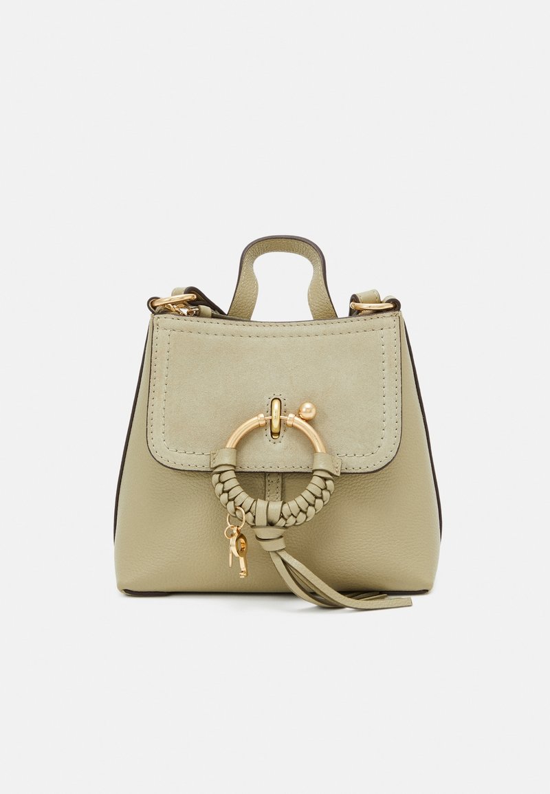 Petit sac à main en cuir vert olive avec un rabat en daim, des ferrures dorées, un anneau tressé en guise d'accent et un pompon décoratif.