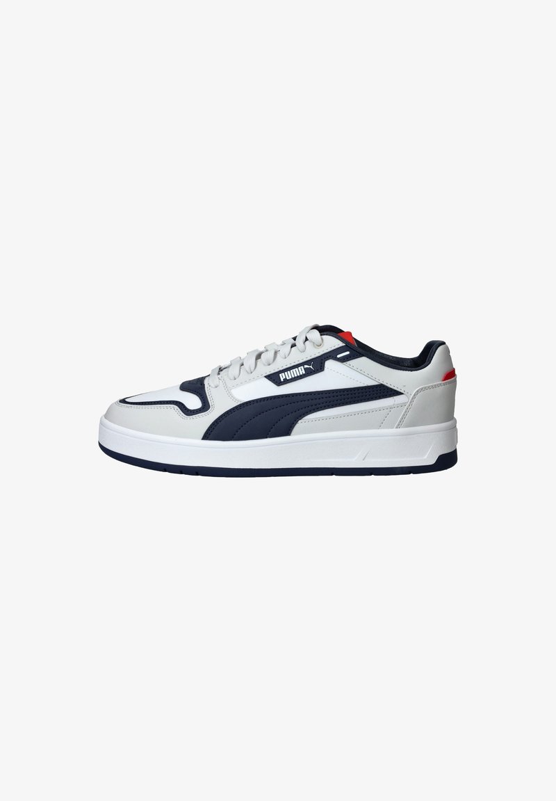 Baskets basses Puma blanches et bleu marine avec lacets, dessus en cuir et accent rouge sur le talon, vues de côté.