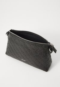 Clutch in pelle nera con una texture a motivo, dotato di una cerniera in argento e di una piccola tracolla. L'interno è visibile, mostrando una fodera scura.
