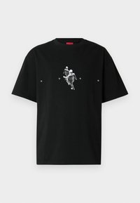 Μαύρο βαμβακερό t-shirt με γραφικό δύο μορφών σε κίνηση, με τη λέξη "HUGO" σε λευκό κείμενο κάτω από το σχέδιο. Κοντά μανίκια, στρογγυλή λαιμόκοψη.