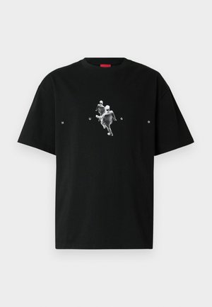 Musta puuvillainen t-paita, jossa on grafiikka kahdesta liikkeessä olevasta hahmosta ja alla valkoisin kirjaimin sana "HUGO". Lyhyet hihat, pyöreä pääntie.