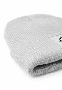 Gray knitted beanie with ribbed texture, featuring a folded cuff and a small label on the side. Soft fabric with a smooth finish.