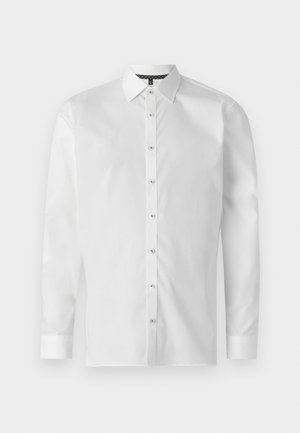 Camicia bianca a maniche lunghe realizzata in tessuto morbido, con colletto classico, chiusura frontale con bottoni e polsini abbottonati. Collo interno con motivo scuro.