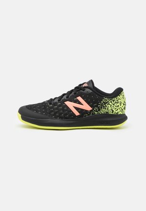 Chaussure de course New Balance noire et jaune fluo avec logo rose, tige en mesh et semelle légère, vue de profil.