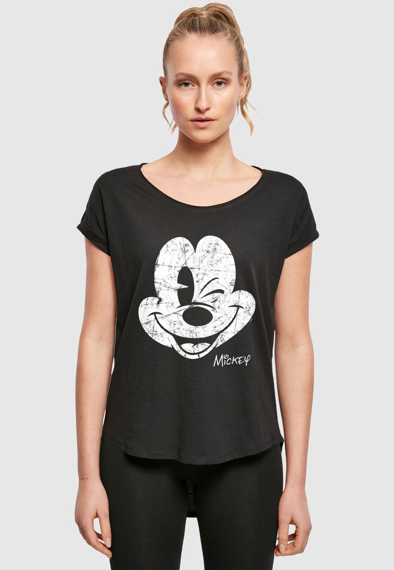 Sort t-skjorte i svart med et slitt hvitt grafikk av en smilende Mickey Mouse foran, med en avslappet passform og rullede ermer.