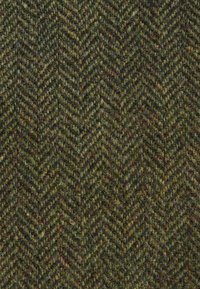 Halászmintás anyag sötétzöld és barna árnyalatokban. Texturált gyapjú szövés látható szálakkal és jellegzetes zig-zag mintával.