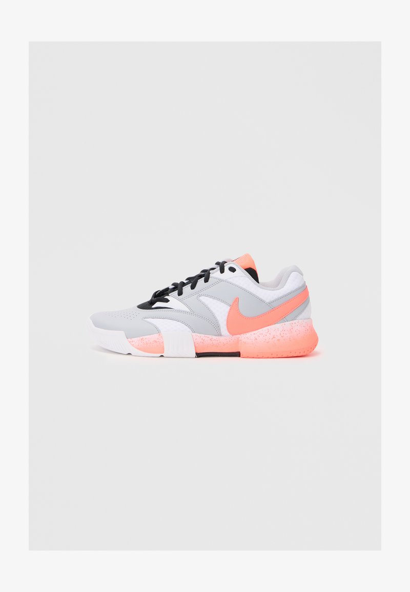 Grey athletic shoe with white and black accents. Features a pink swoosh logo and a textured, pink-speckled sole. Laces are black.