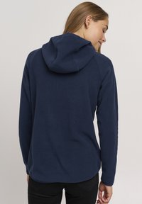 Felpa con cappuccio blu navy in fleece, con orlo arrotondato, maniche lunghe e cappuccio. Texture morbida senza motivi visibili o dettagli in metallo.