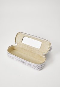 Estuche para lápices con cremallera, con un exterior blanco texturizado que presenta un patrón sutil, un interior forrado en beige suave y un espacio rectangular para un espejo.