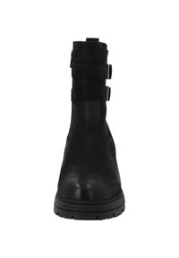 Botín negro con acabados de ante, dos correas decorativas, punta redondeada y suela de goma resistente. Textura suave en la zona del dedo del pie.