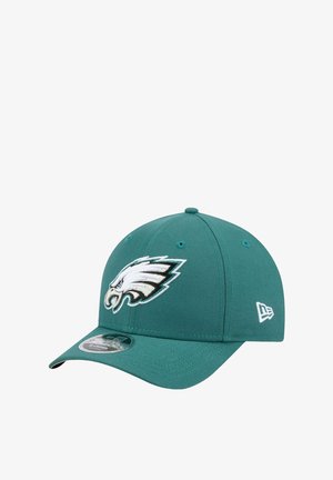 Teal cap made of fabric, featuring an embroidered white eagle logo on the front. Curved brim with a size tag on the underside.