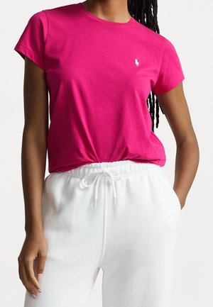 Fuchsia katoenen T-shirt met ronde hals en korte mouwen, met een klein wit logo op de linkerborst, gecombineerd met witte sweatpants met trekkoord.