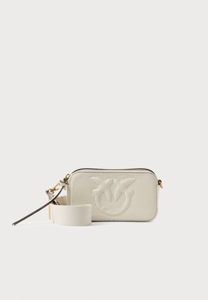 Prisutna je pravokutna crossbody torba od kremasto kože s urezanim uzorkom, zatvaranjem na patentni zatvarač i odvojivim remenom. Ima glatku teksturu i suptilne metalne detalje.