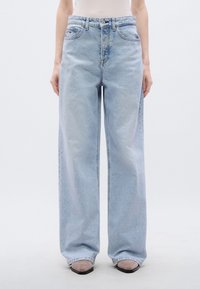 Φαρδιά τζιν παντελ όνια σε ανοιχτό γαλάζιο χρώμα, κατασκευασμένα από τζιν ύφασμα, με ψηλή μέση, παραδοσιακό πεντάτσεπο σχέδιο και διακριτική ξεθώριασμα σε όλο το ύφασμα.