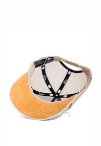 Gorra con visera plana y redondeada en ante color beige. El interior cuenta con un forro de malla y acentos en negro con detalles del logo en blanco. Etiquetas visibles.