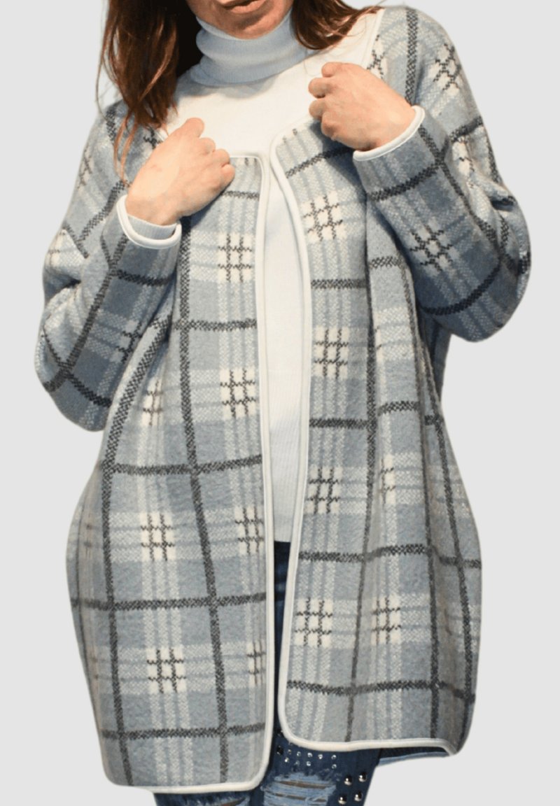 Cárdigan a cuadros en gris claro y azul, con una textura suave, diseño de frente abierto y ribete blanco en contraste. Lleva sobre un cuello alto blanco.