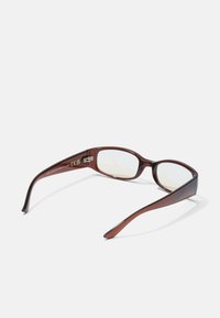 Ruskoset rectangular sunglasses z läpinäkyvilla kehillä ja kirkkailla linsseillä. Varustettu kaarevilla varsilla ja joustavilla jousineen.