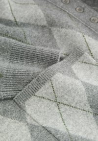 Pull en gris avec un motif en losanges en gris clair et vert. Texture douce, poignets côtelés et design à cinq boutons.